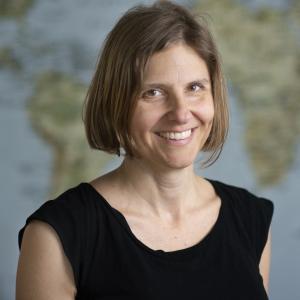 Profile photo of Anya Nartker in front of a world map